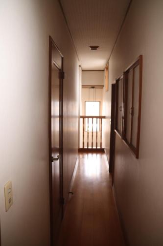 an empty room with a hallway with two doors at 我孫子ハウス in Abiko