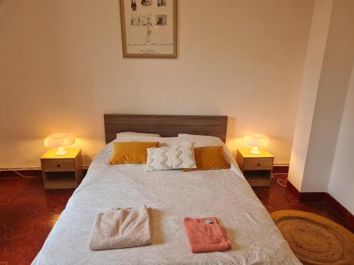 a bedroom with a bed with towels on it at Appartement nimes centre160m2 climatisation 3 chambres avec parking in Nîmes