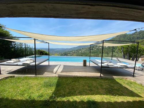 - une vue sur la piscine avec 2 lits dans l'établissement Splendide authentique Mas, à Cabris