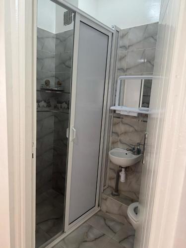 a bathroom with a shower and a toilet and a sink at Bel appartement tout équipé in Agadir