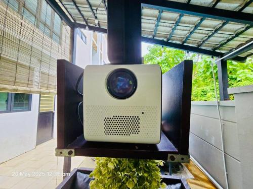 a tv sitting on a table with a plant at Cozy Villa - Private Pool, 5BR, KTV, BBQ, PS5 just 3 Mins to Batu Ferringhi Beach! in Batu Ferringhi