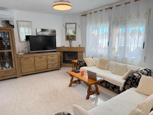 a living room with a couch and a tv at Turisblo villa carmen in Benicarló