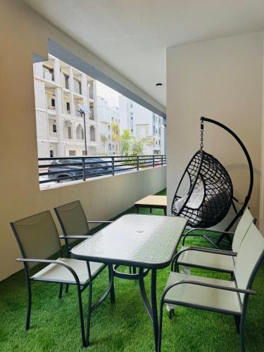a balcony with chairs and a table and a swing at NEW VIP FLAT in Murooj Al Zain, Salalah in Salalah