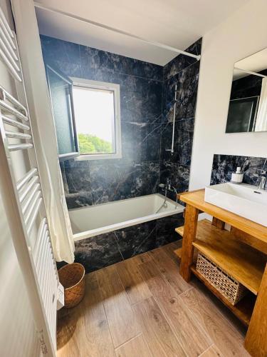 une salle de bain avec un lavabo et une baignoire dans l'établissement La maison dans la prairie fleurie, gîte coquelicot, à Saint-Avit-Sénieur