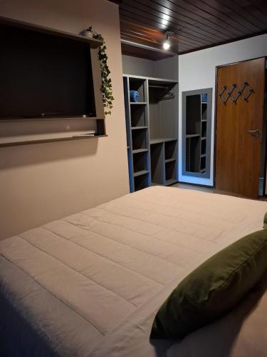 a bedroom with a large bed with a flat screen tv at Flamboyant Residence in Fernando de Noronha