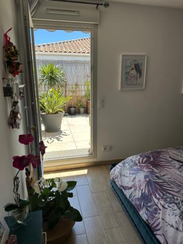 une chambre avec une porte ouverte sur un patio dans l'établissement Symphonie Sur Parc, à Hyères