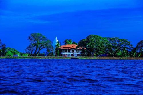 a house on a island in the middle of a body of water at Tissa Yala Lake View Hotel in Tissamaharama