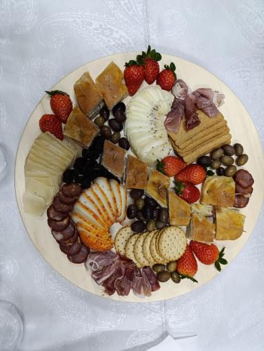 a plate filled with different types of cheese and fruit at Cosy Historical House in Lamego - Quinta do Cabo in Lamego