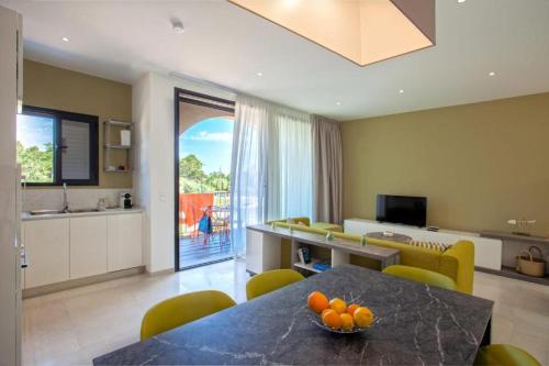 un salon avec une table avec des oranges dessus dans l'établissement Appartement E RONDINELLE 3, à Belgodère