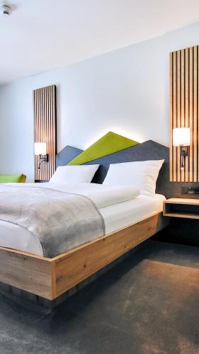 a large bed in a room with two lamps at Mountain View Hotel Willingen, BW Signature Collection in Willingen