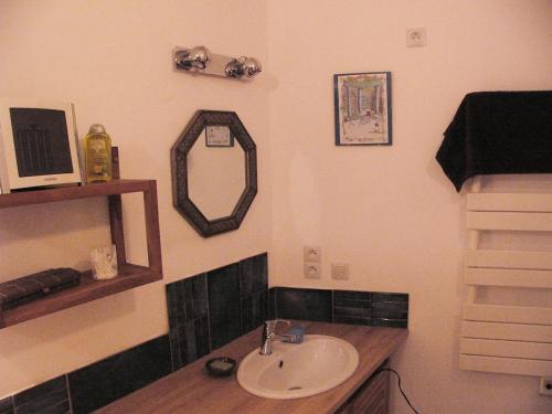 une salle de bain avec un lavabo et un miroir dans l'établissement MAISON avec VUE PANORAMIQUE, à La Celle-sous-Gouzon