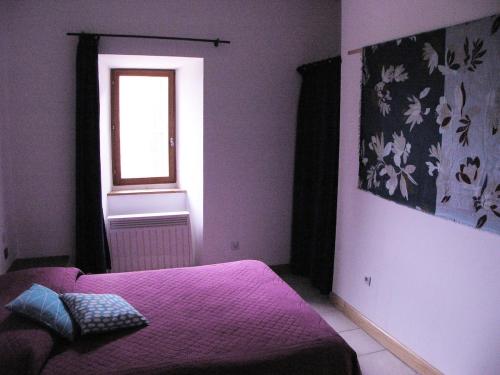 une chambre avec un lit violet et une fenêtre dans l'établissement MAISON avec VUE PANORAMIQUE, à La Celle-sous-Gouzon