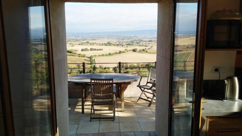 - un balcon avec vue sur une table et des chaises dans l'établissement MAISON avec VUE PANORAMIQUE, à La Celle-sous-Gouzon