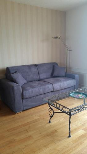 - un canapé bleu dans le salon avec une table en verre dans l'établissement Ker Stella, à Plérin