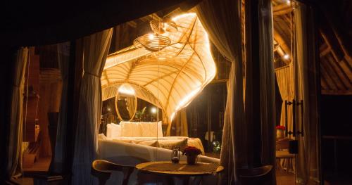 ウブドにあるBELALU Bali Boutique & SPA experienceのベッド、テーブル、鏡が備わる客室です。