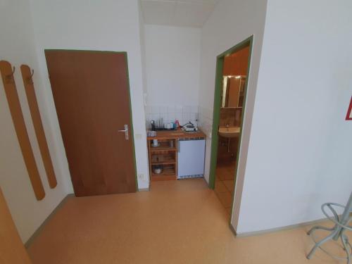 a room with a kitchen with a desk and a door at Zirbitzblick in Zeltweg