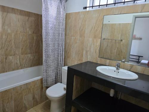 un bagno con lavandino, water e specchio di Lazy Tilapia a Baie du Tombeau