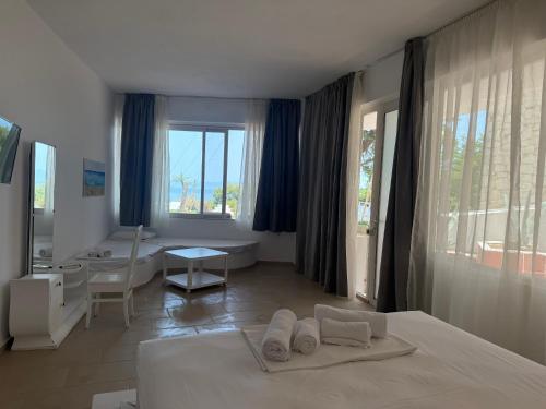 卡利塞亚-豪客迪克斯Amelia Seaview Apartments & Studios的白色卧室设有床、桌子和窗户