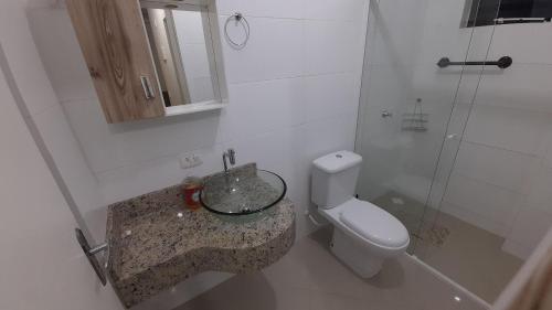a bathroom with a toilet and a sink and a shower at Incrível localização 102, apenas 4 min do Parque in Piratuba