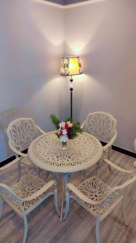 a table and chairs with a lamp and flowers on it at Tuli Orchid in Rāmtek