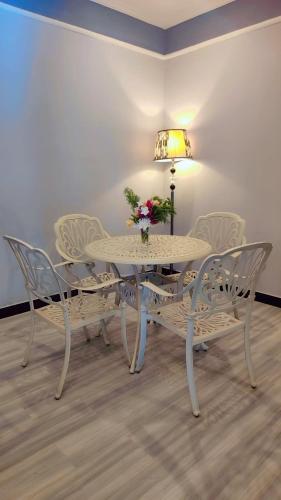a white dining room table with chairs and a lamp at Tuli Orchid in Rāmtek