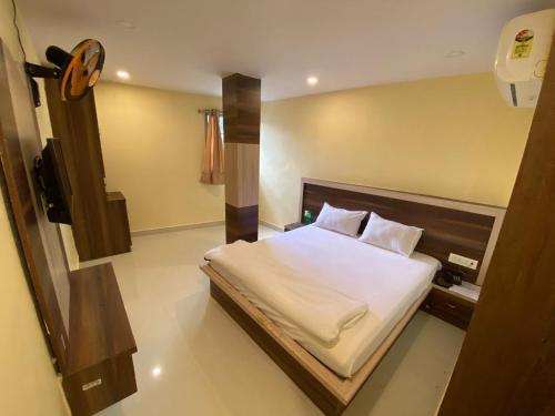 een slaapkamer met een bed met witte lakens en kussens bij Hotel star in Rānchī
