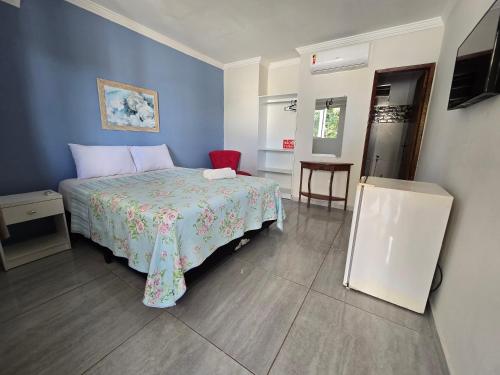 a bedroom with a bed with a blue wall at Porto De Galinhas Pousada Raízes Do Porto in Porto De Galinhas