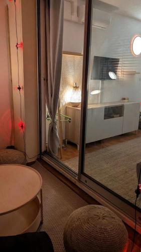 une pièce avec une porte vitrée avec une table et une pièce avec une cuisine dans l'établissement La mer à deux, à La Grande Motte