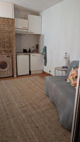 un salon avec un canapé et une cuisine dans l'établissement La mer à deux, à La Grande Motte