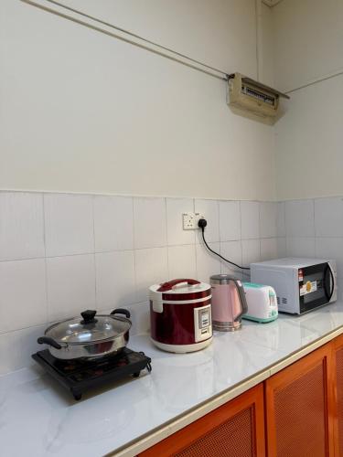a kitchen counter with a stove and a microwave at Cozy Stay -APU, Bukit Jalil, UPM in Serdang