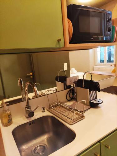 un comptoir de cuisine avec un évier et un micro-ondes dans l'établissement Superb central apartment, air-conditioned, parking, à Saint-Tropez