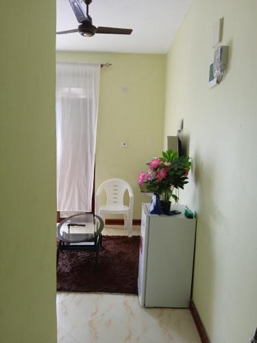 a living room with a television and a chair at JOLANDA STUDIO APARTMENTs in Mtwapa