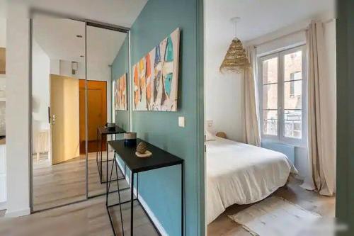 une chambre avec un lit et une table dedans dans l'établissement Logement St Malo Centre - Emplacement idéal 20 min à pied Intra-Muros & grande plage du Sillon, à Saint-Malo