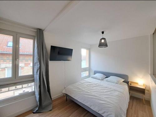 - une chambre avec un lit, une télévision et 2 fenêtres dans l'établissement Bologne - 2 People - Paisible- Centre-ville, à Reims