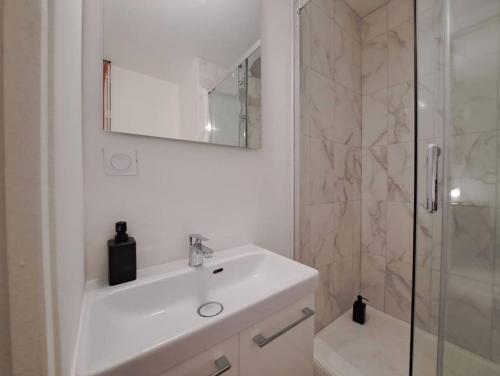 une salle de bain blanche avec un lavabo et une douche dans l'établissement Bologne - 2 People - Paisible- Centre-ville, à Reims
