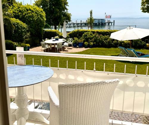 a balcony with a table and chairs and the ocean at Boutique Hotel Villa am See in Hagnau
