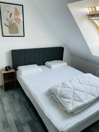 - un lit blanc avec une tête de lit verte dans une chambre dans l'établissement Ker a lévénez, à Cancale