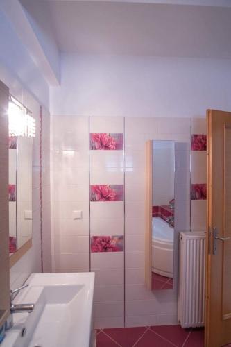 a white bathroom with a sink and a mirror at Ria Villa Preveza in Kalamitsi