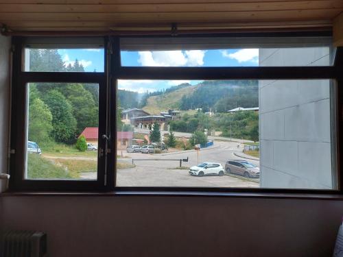 une fenêtre avec vue sur un parking dans l'établissement Belle-Hutte le 8bis, à La Bresse