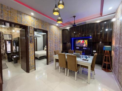 a dining room with a table and chairs and a television at Entire 3bhk Luxury Flat in Zirakpur-Panchkula-Chandigarh-Mohali, Punjab, India in Zirakpur