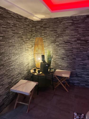 une pièce avec une table et des chaises et un mur de briques dans l'établissement Beauty Sun love, à Portet-sur-Garonne