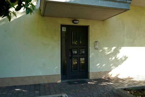 a black door on a building with a brick walkway at Manoppello Scalo Two-room apartment & parking in Brecciarola