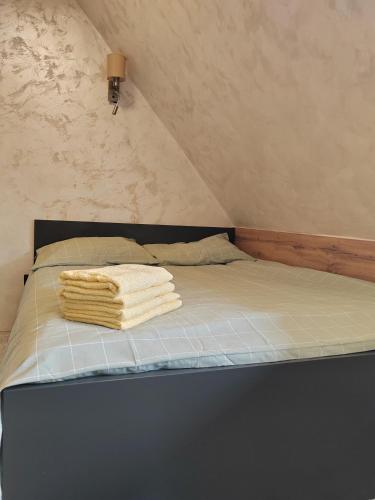 a bed with two towels on top of it at Kopaonik centar - Konaci, lux apartment ANDREA in Kopaonik