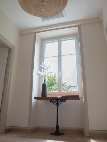 a window with a vase on a table in a room at Les chambres de la Marquise in Martel