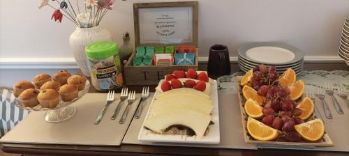 a table with a plate of food with fruit on it at Twin Oaks Bed & Breakfast in Kilkenny