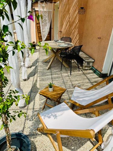 a patio with chairs and a table and a table at Casa Papavero in Gambarogno