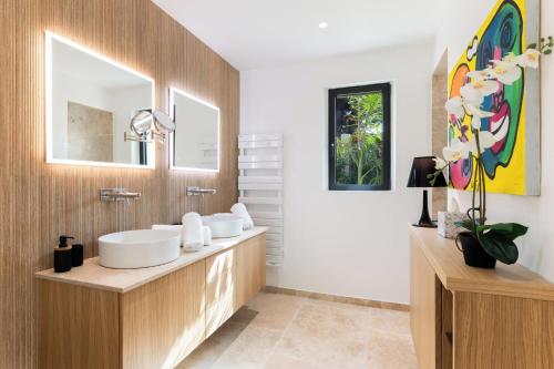 un baño con dos lavabos y dos espejos en Villa Orchard, en Saint-Tropez
