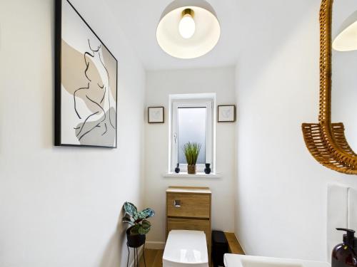 a living room with white walls and a mirror at Luxury Beach Stay with Hot Tub in Burry Port