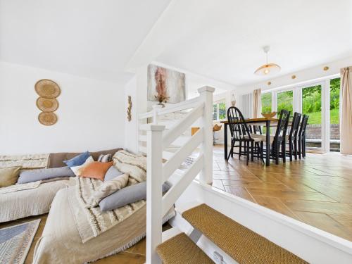 a white bedroom with a bed and a dining room at 5-Bed Retreat with Hot Tub, Garden & Relaxing Views in Burry Port