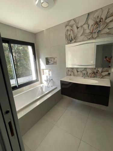 La salle de bains est pourvue d'une baignoire, d'un lavabo et d'une baignoire. dans l'établissement Magnifique, villa, spacieuse et lumineuse, à Rocbaron